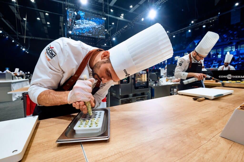 Photographie réalisée lors du Bocuse d'Or. Un chef étoilé est en train de confectionner un entremet