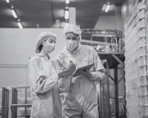 Deux personnes dans un entrepôt analysant les stocks par le biais d'une tablette.