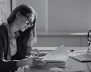 Portrait d'une jeune femme travaillant sur une facture. Image d'illustration pour un webinar sur la facturation électronique proposée par Sage.