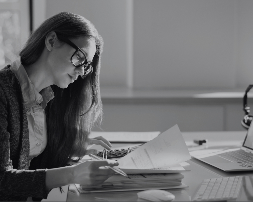 Portrait d'une jeune femme travaillant sur une facture. Image d'illustration pour un webinar sur la facturation électronique proposée par Sage.
